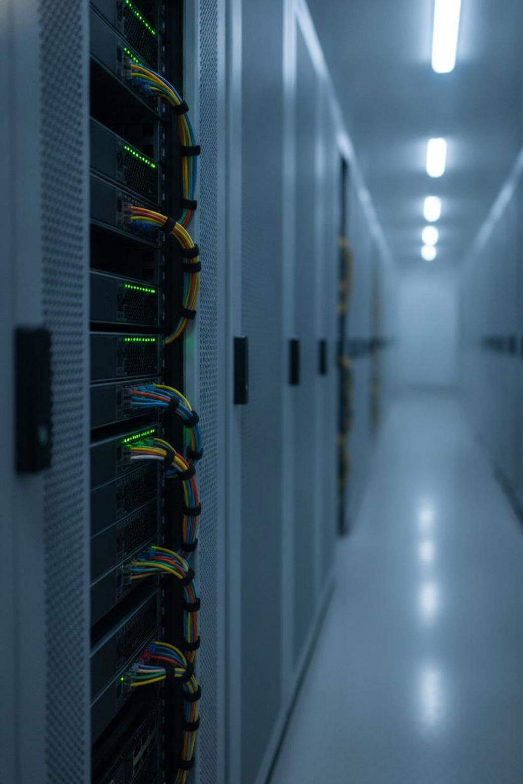 Rack-mounted servers in data center corridor powering new autonomous AI agent assistant 2026 workflows, blue-white lighting